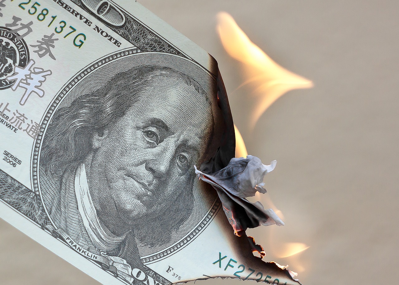 paper currency inflation - burning dollar